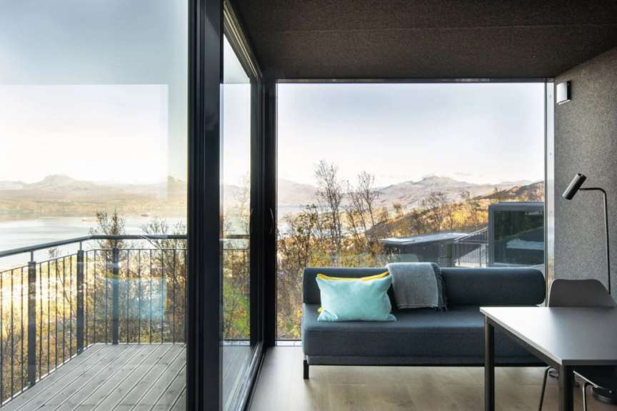 Ein Wohnzimmer mit einer Couch und einem Tisch mit Blick auf einen See