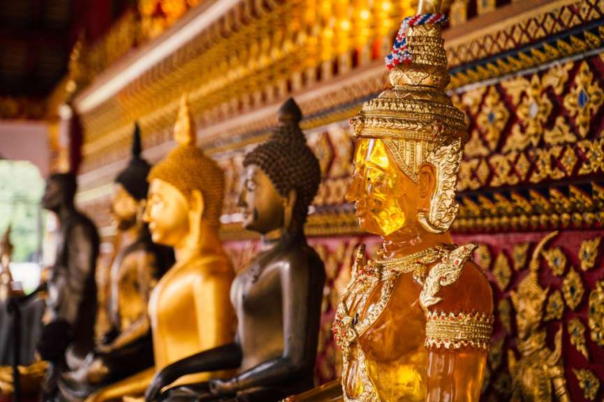 Eine Reihe von goldenen buddhistischen Statuen in einem Tempel