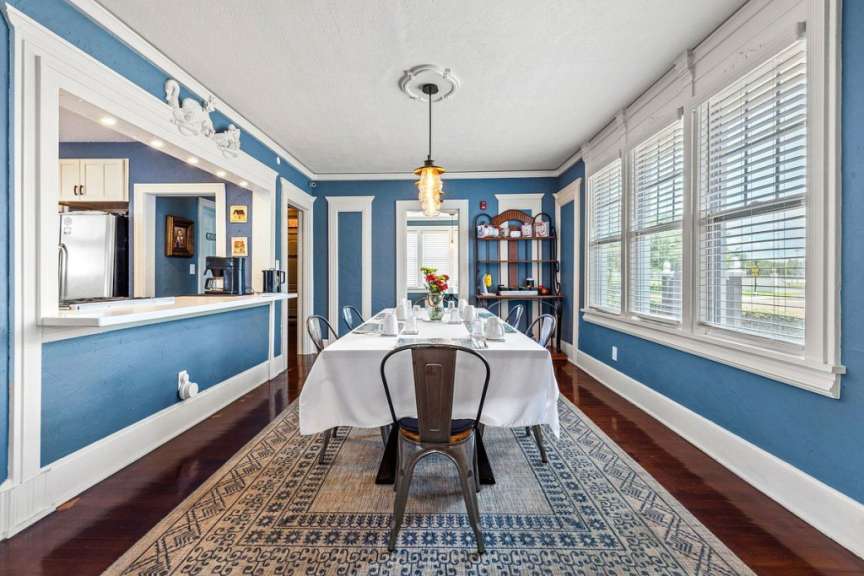 Ein Esszimmer mit blauen Wänden und weißen Möbeln