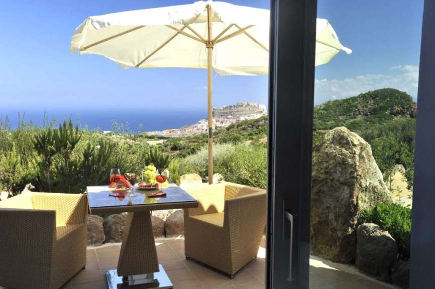 Ein Tisch und Stühle auf einem Balkon mit Blick auf den Ozean