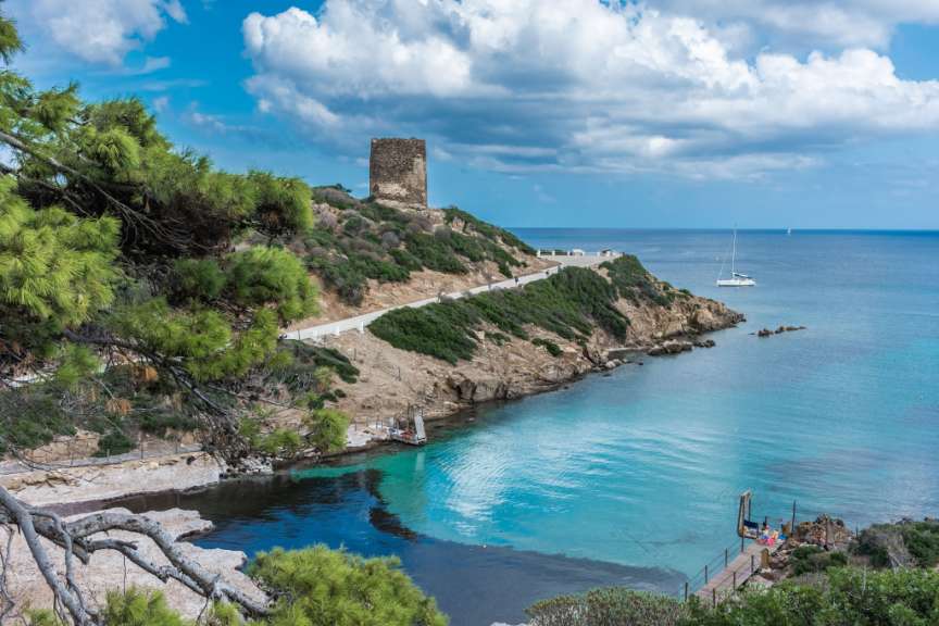 Ein Blick auf einen Strand mit einem Turm im Hintergrund