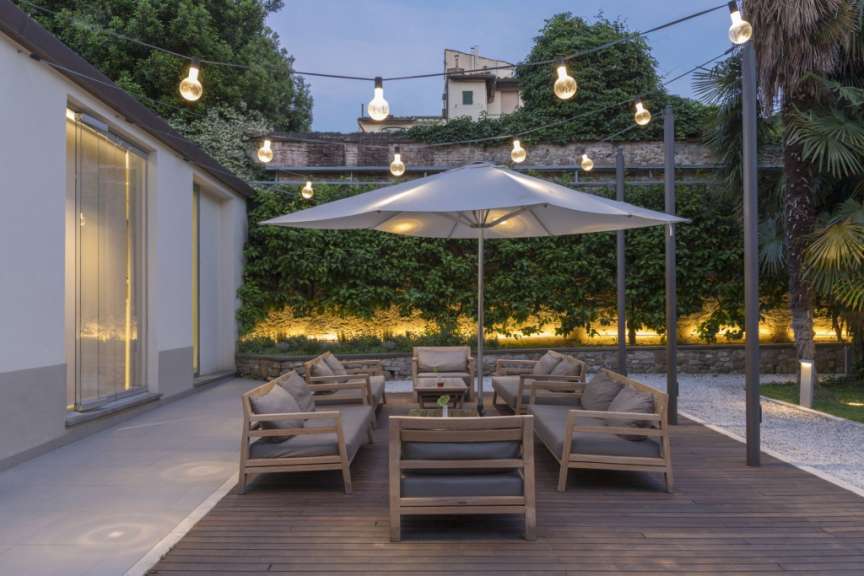 Eine Terrasse mit Möbeln und einem großen Sonnenschirm