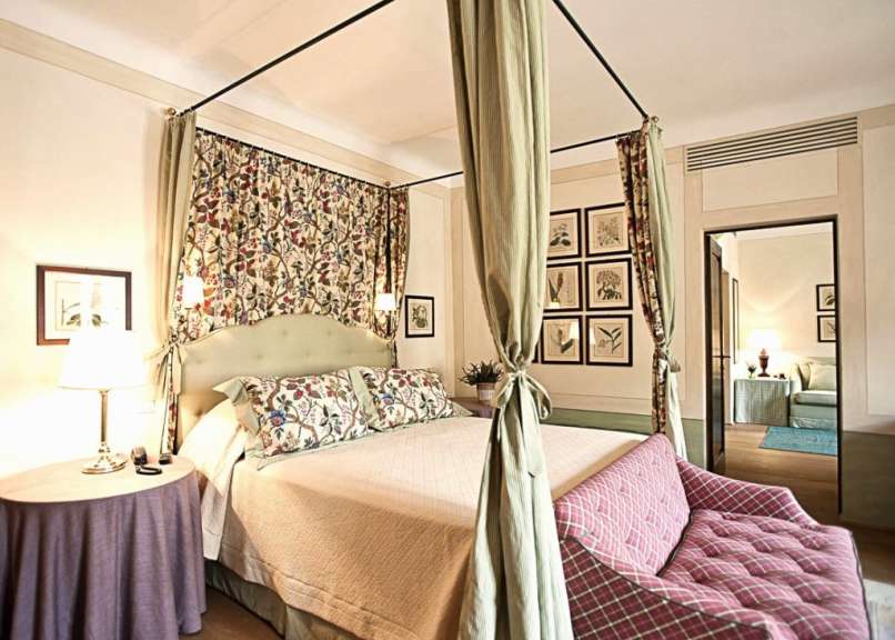 Ein Schlafzimmer mit einem Himmelbett und einer Couch
