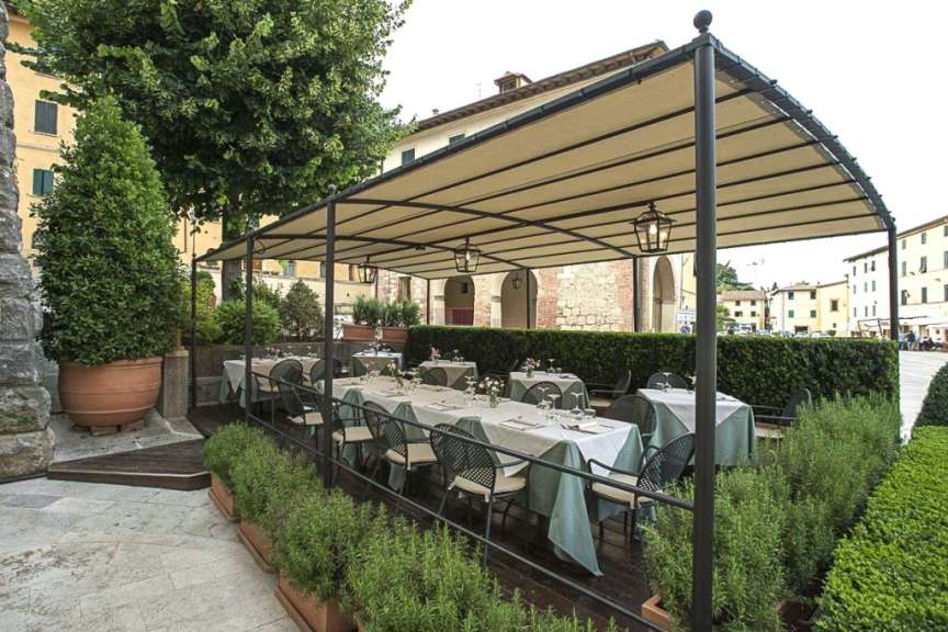 Ein Restaurant mit Tisch und Stühlen unter einem Zelt