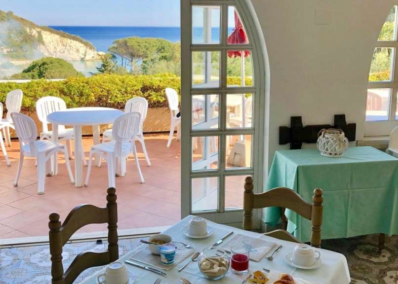 Ein Tisch und Stühle in einem Restaurant mit Blick auf den Ozean