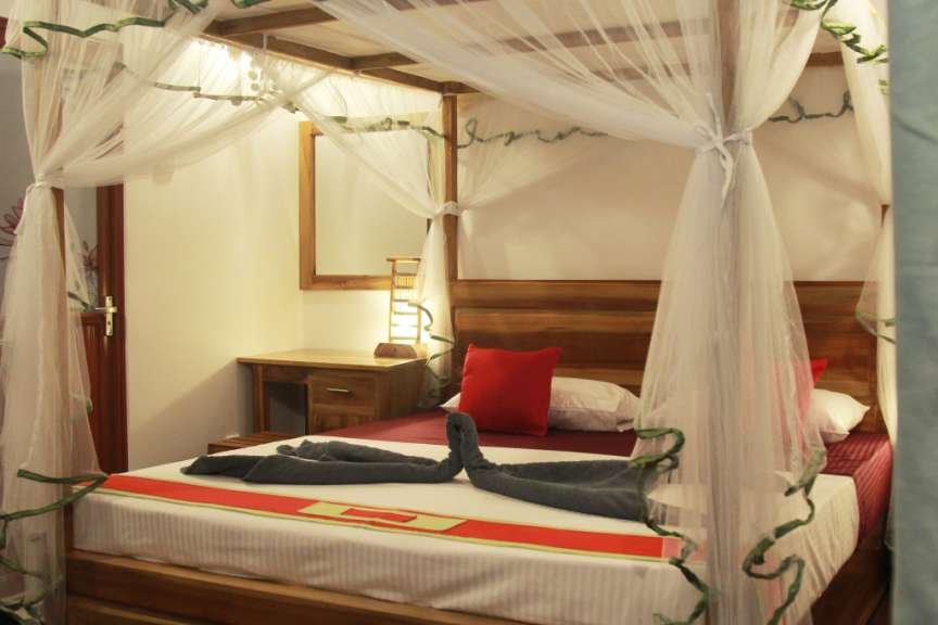 Ein Schlafzimmer mit einem Himmelbett und einem Spiegel