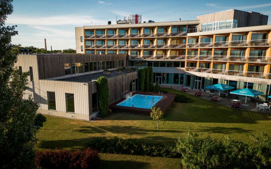 Ein großes Hotel mit einem Pool und blauen Sonnenschirmen