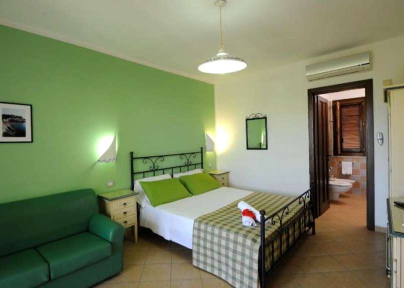 Ein Schlafzimmer mit grünen Wänden und einem Bett