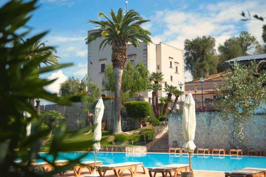 Ein großes weißes Gebäude mit einem Pool davor