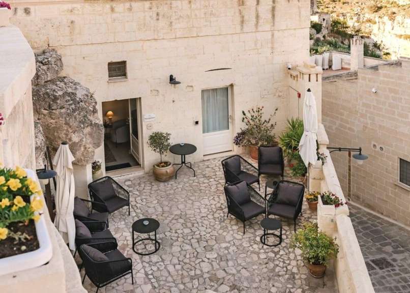 Eine Terrasse mit Stühlen und Tischen vor einem Gebäude