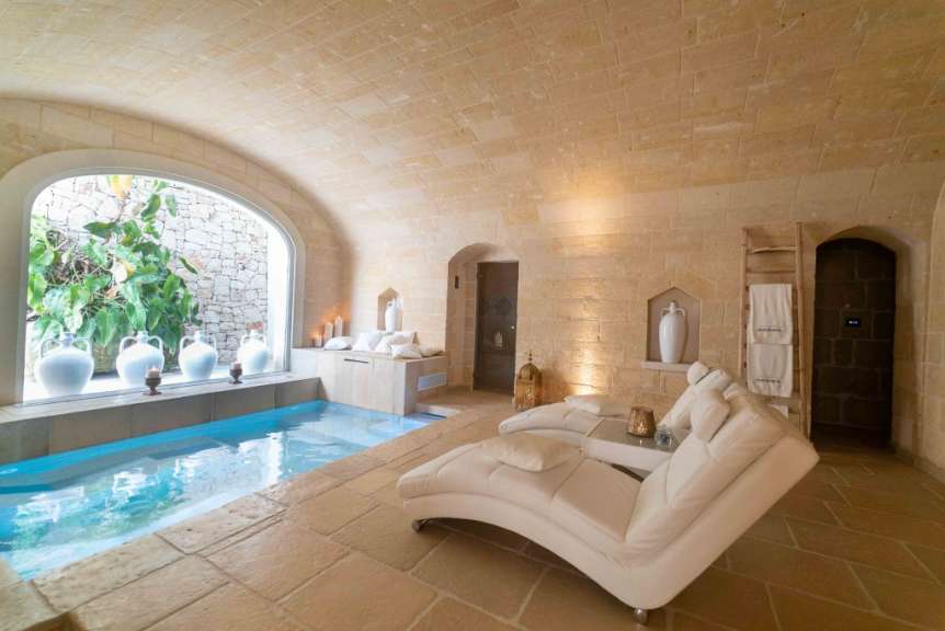 Ein weißer Stuhl sitzt in einem Raum mit einem Pool