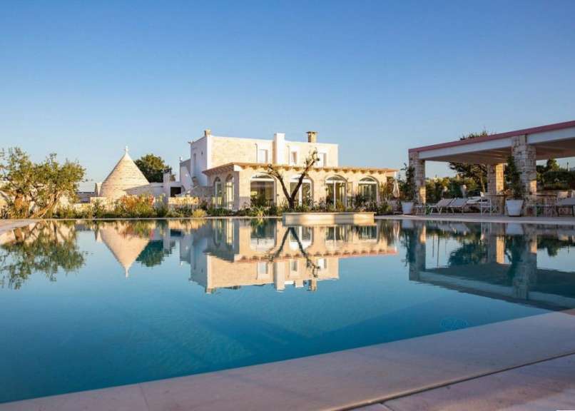 Ein großer Swimmingpool mit einem weißen Haus im Hintergrund