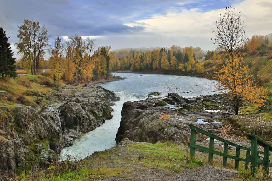 Ein Wasserfall in einem Fluss mit Bäumen im Hintergrund