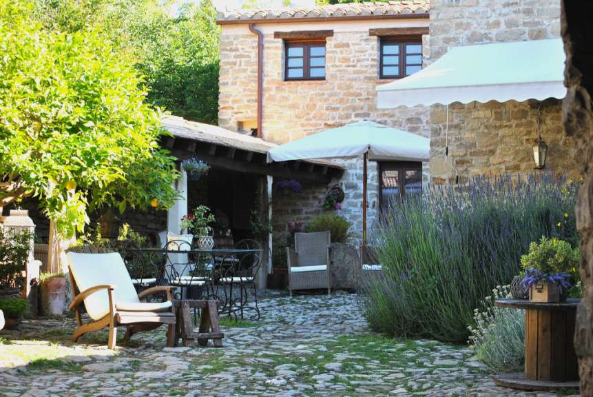 Eine Terrasse mit Tisch und Stühlen und einem weißen Regenschirm