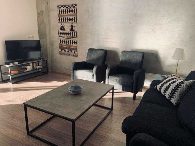 Ein Wohnzimmer mit einem Couchtisch und zwei Stühlen