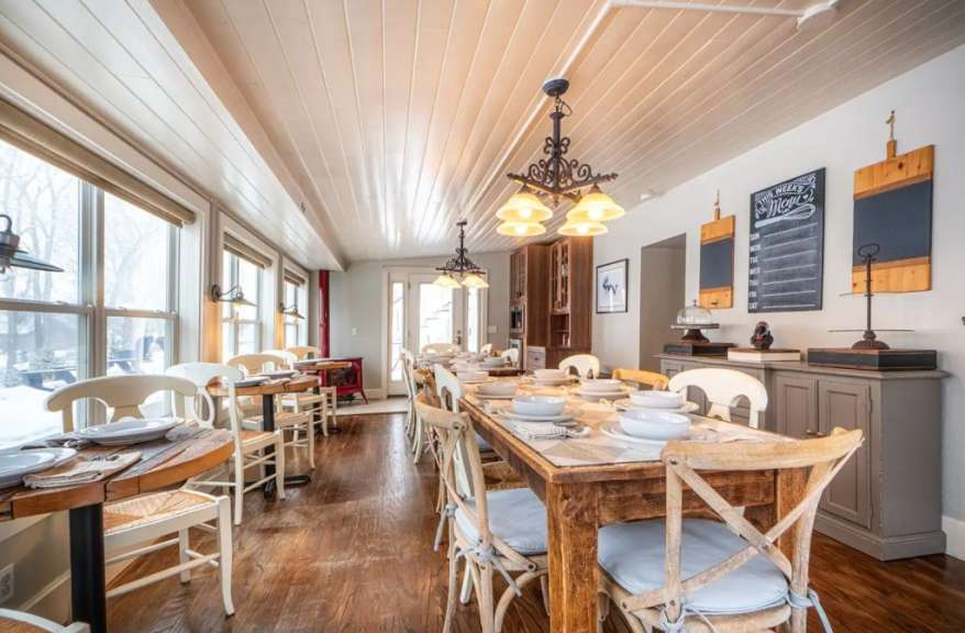 Ein langes Esszimmer mit vielen Tischen und Stühlen