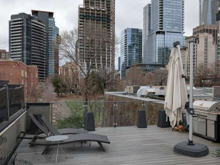 Ein Deck mit Liegestühlen und einem Grill mit Blick auf die Stadt