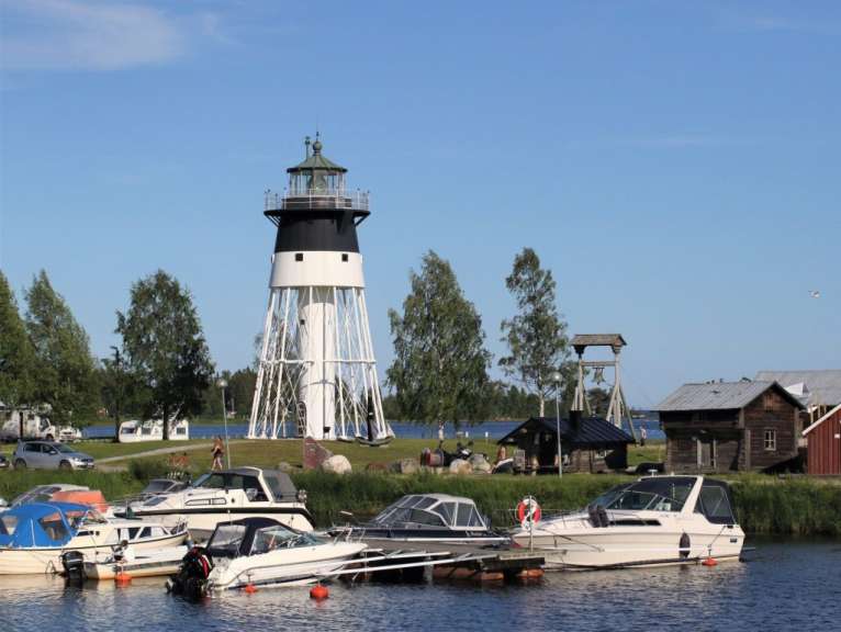 Ein schwarz-weißer Leuchtturm steht über einem See