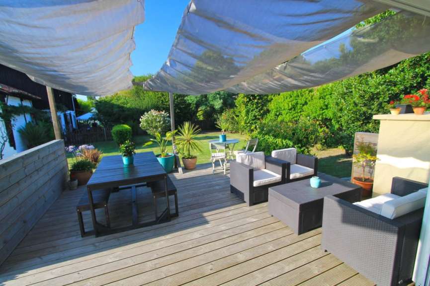 Eine Terrasse mit einem Tisch und Stühlen und einer weißen Decke