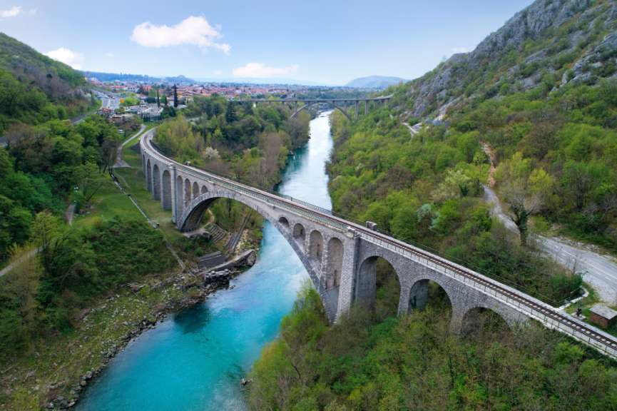 Ein Zug fährt auf einer Brücke über einen Fluss