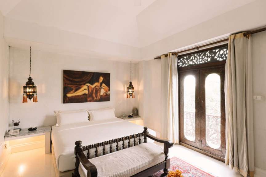 Ein Schlafzimmer mit einem Bett und einem Gemälde an der Decke