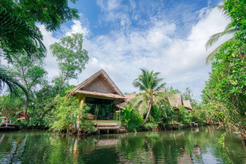 Ein Haus mit Strohdach sitzt an einem Fluss