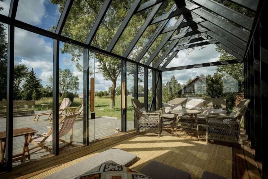 Ein Wohnzimmer mit vielen Fenstern und Möbeln