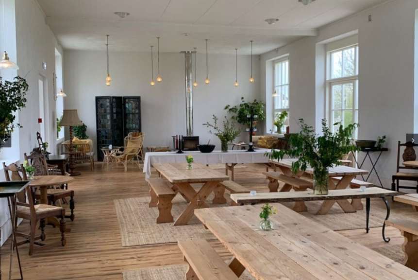 Ein großer Raum mit vielen Holztischen und Bänken