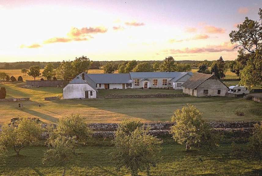 Ein großes weißes Haus steht inmitten eines grünen Feldes