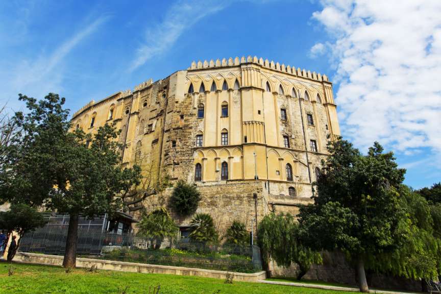 Ein großes Gebäude mit vielen Fenstern steht auf einem Hügel