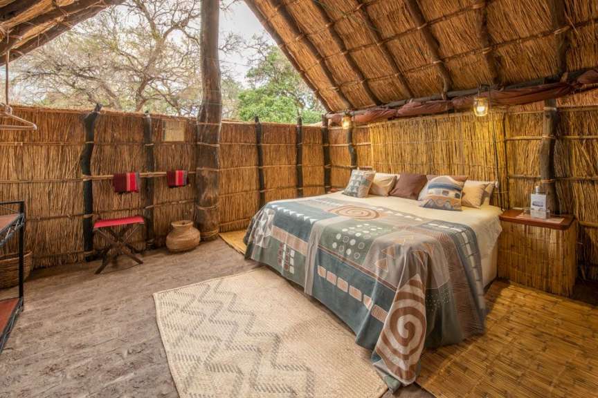 Ein Zimmer mit einem Bett und einem Tisch aus Stroh