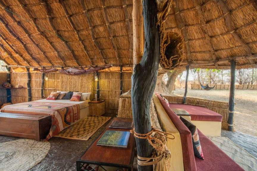 Ein Zimmer mit einem Strohdach und einem Bett