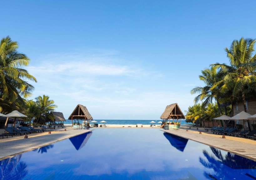 Ein großer blauer Pool führt zum Strand