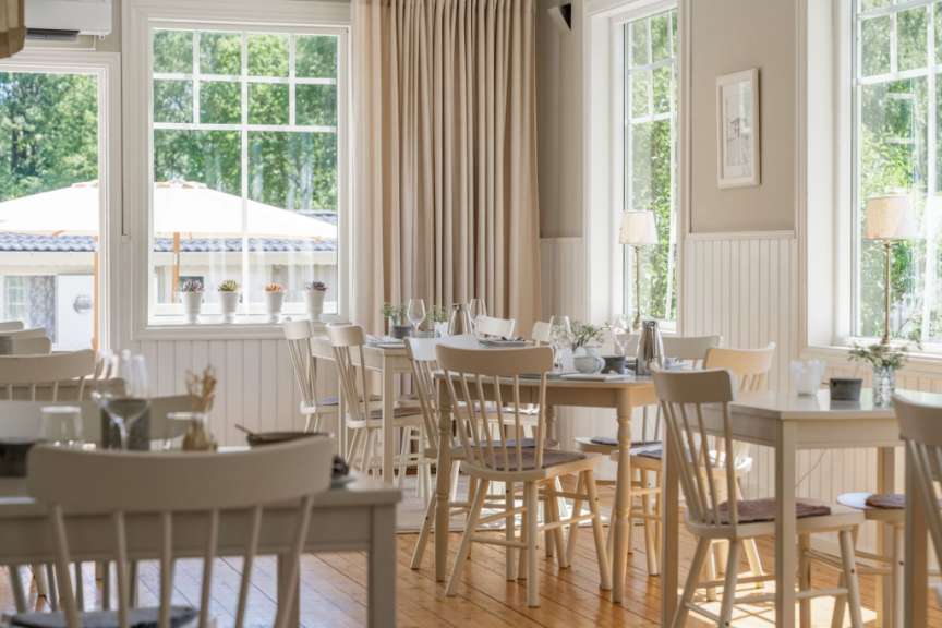Ein Esszimmer mit vielen Tischen und Stühlen