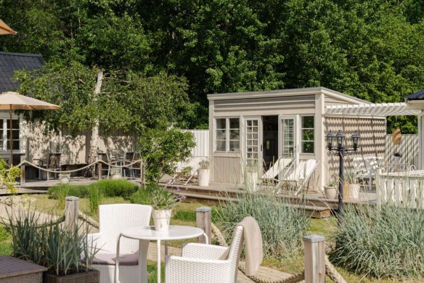 Ein kleines Haus mit einem Tisch und Stühlen davor