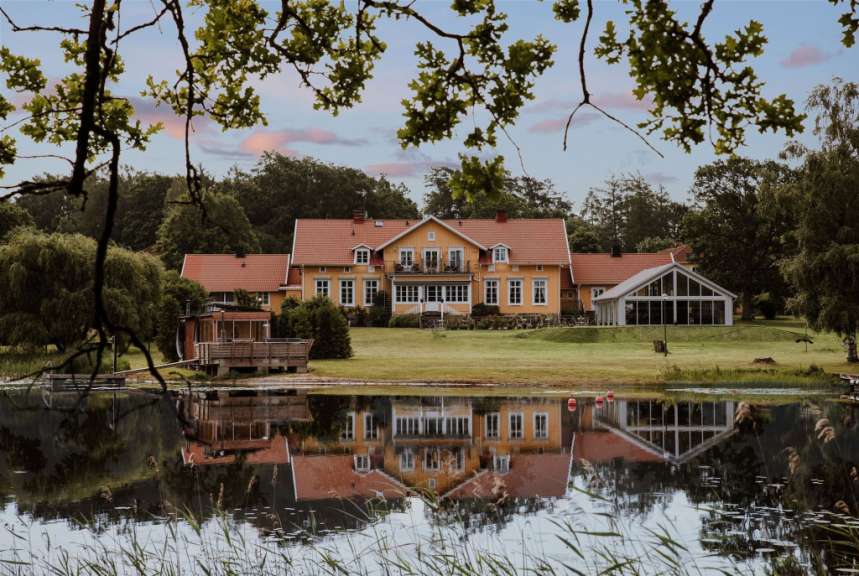 Ein großes Haus spiegelt sich in einem Teich