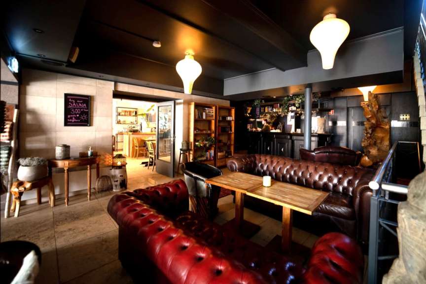 Ein Wohnzimmer mit roten Ledersofas und Holztischen