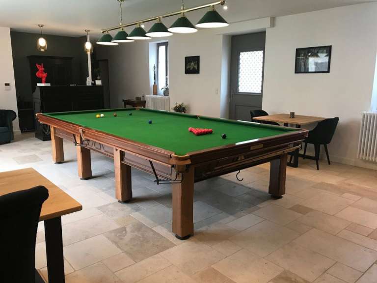Ein Pooltisch in einem Raum mit einer grünen Tischdecke