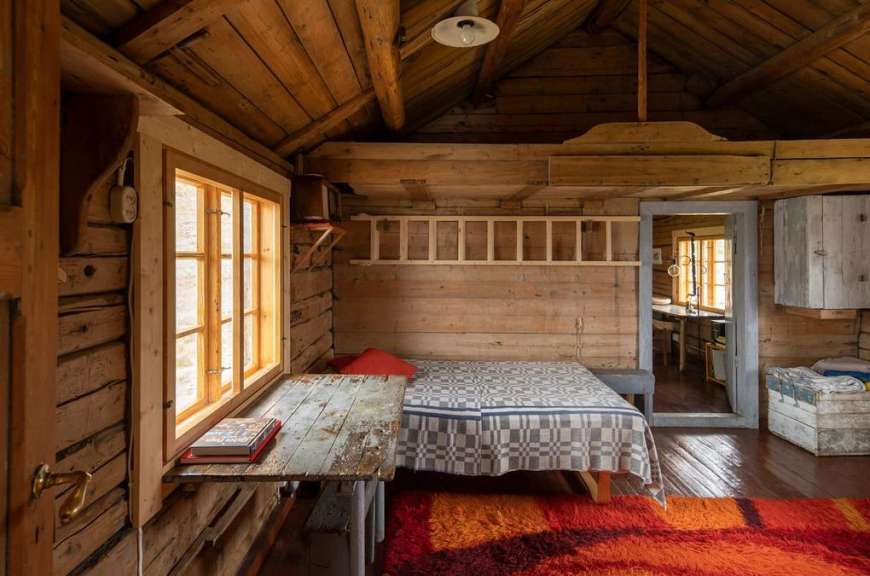 Ein Holzzimmer mit einem Bett und einem Tisch