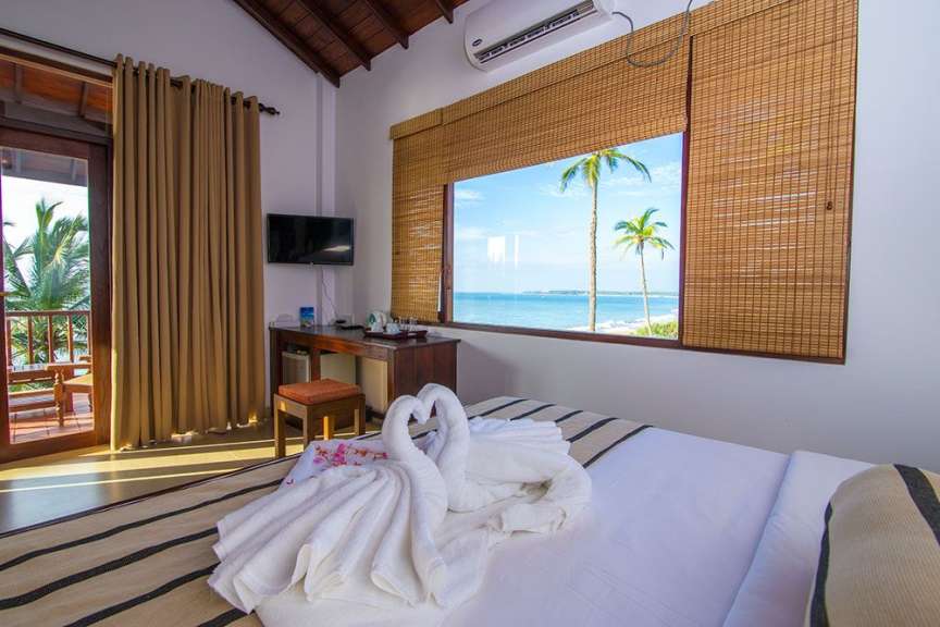 Ein Hotelzimmer mit Meerblick und zwei Handtuch-Schwäne auf dem Bett.