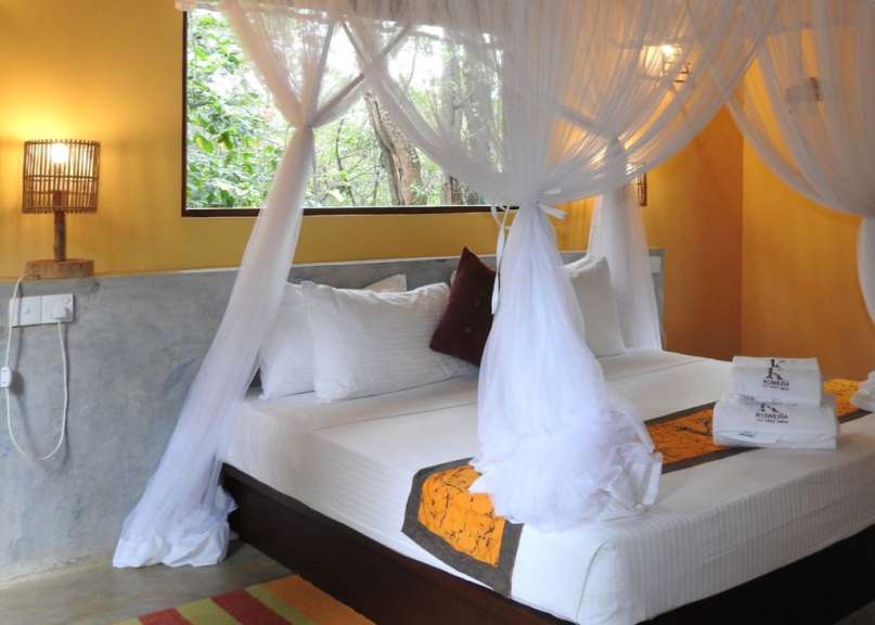 Ein Bett mit einem weißen Vorhang und zwei Handtüchern mit der Aufschrift ‚ ayurveda ‘ darauf