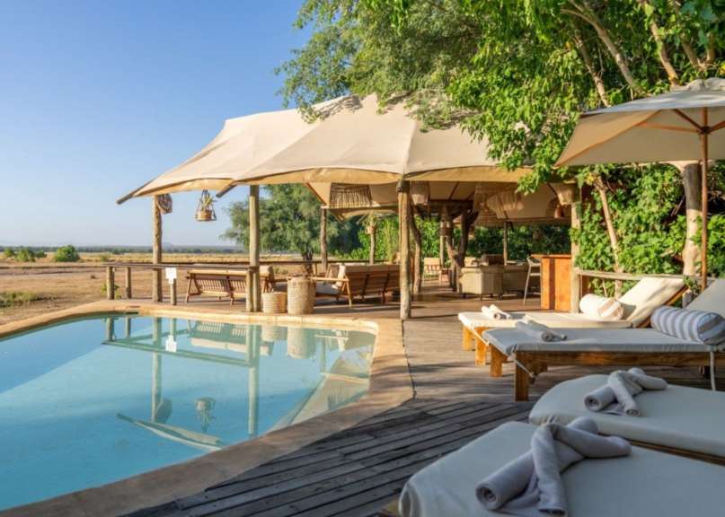 Ein Swimmingpool mit Liegestühlen und einem Zelt dahinter