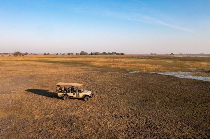 Eine Gruppe von Menschen fährt in einem Geländewagen durch ein Feld