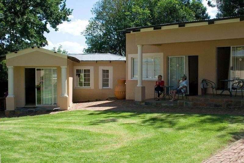 Eine Frau sitzt auf einem Stuhl vor einem Haus