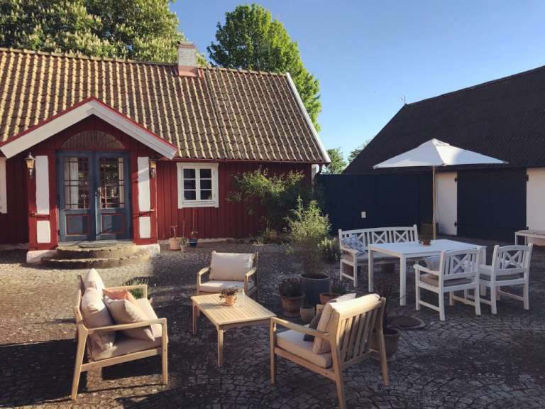 Ein kleines rotes Haus mit einem Tisch und Stühlen davor