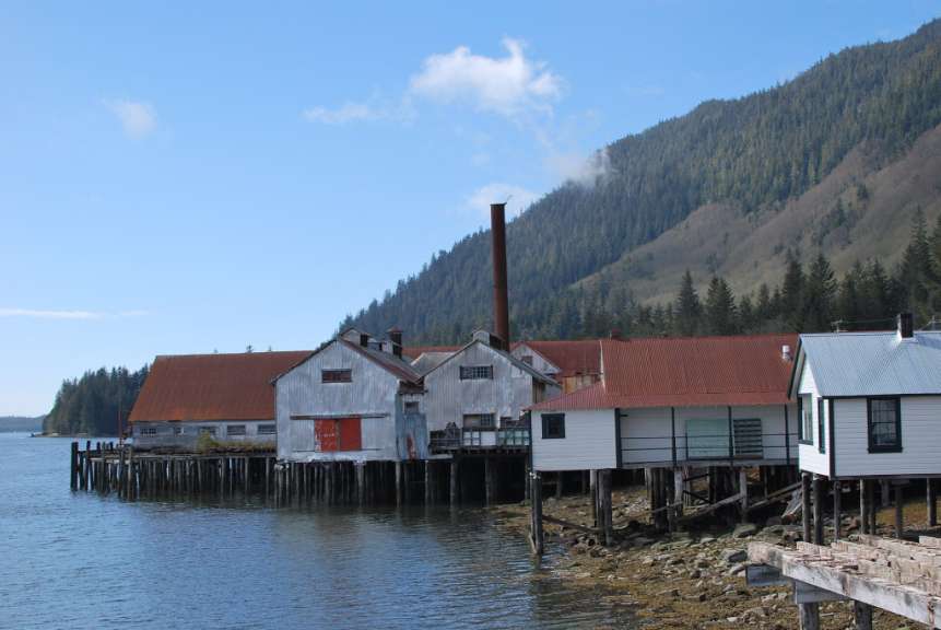 Ein Gebäude mit einem roten Dach sitzt am Ufer eines Sees