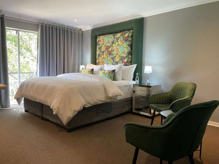 Ein Schlafzimmer mit einem großen Bett und zwei Stühlen