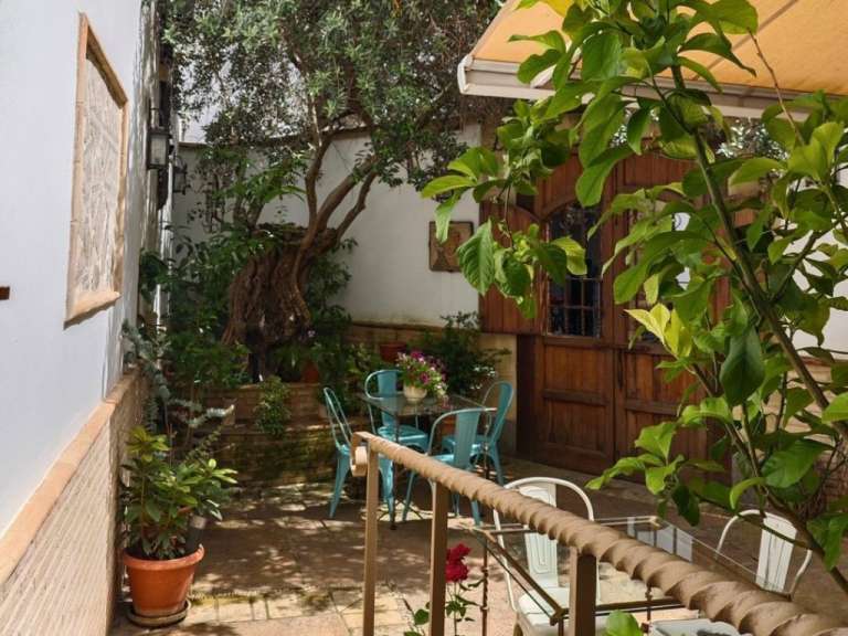 Eine Terrasse mit einem Tisch und Stühlen und einem Baum
