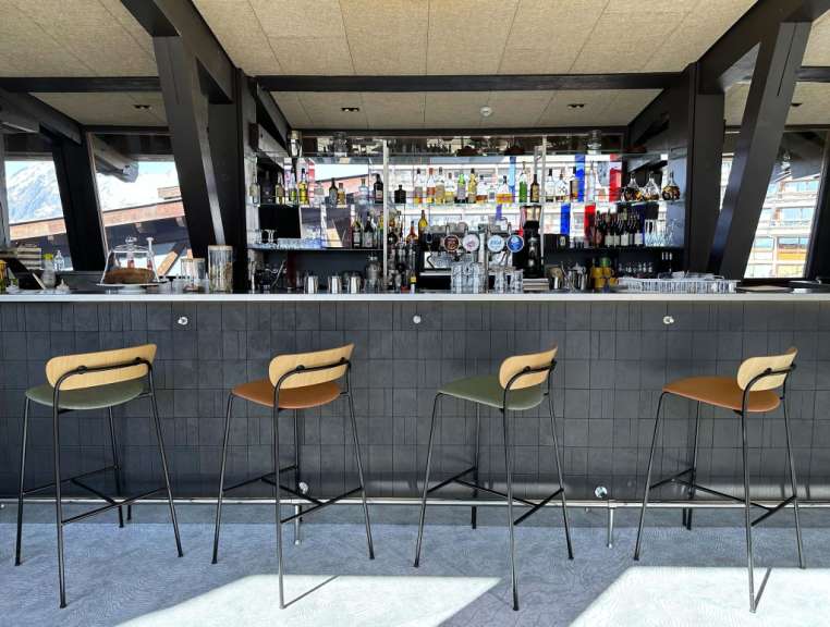 Barhocker stehen an einer Bar mit vielen Getränken