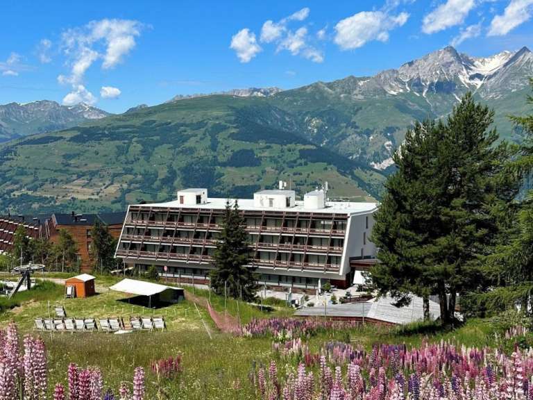 Ein großes Gebäude steht inmitten einer Bergkette